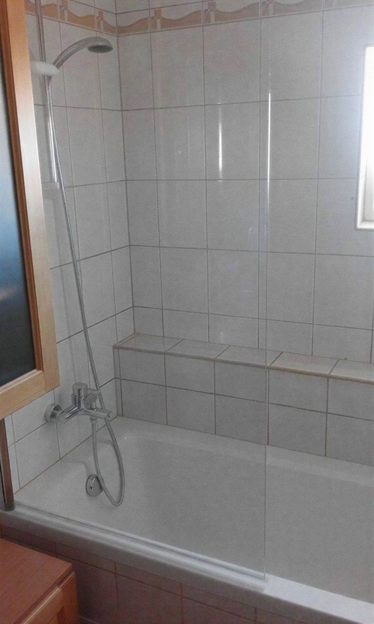 Kád zuhanyfallal és csempézett párkánnyal