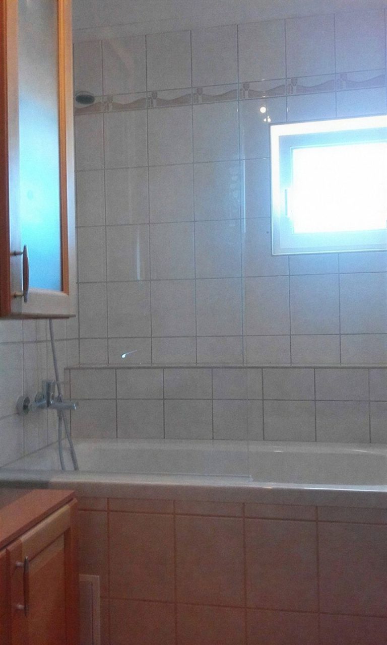 Kád csempézett fürdőszobában, ablakkal