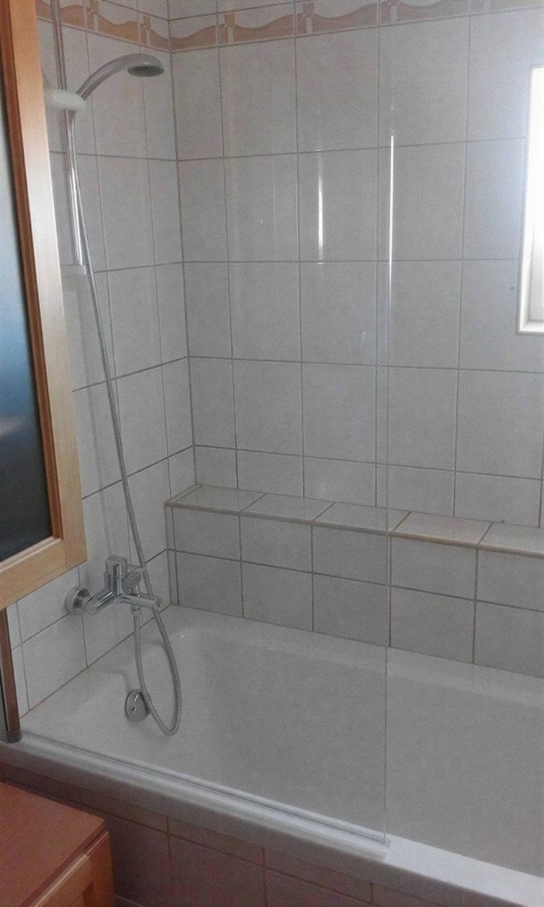 Kád zuhanyfallal és csempézett párkánnyal