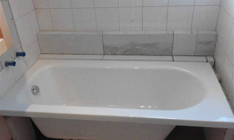 Beépített kád csempézett falak között