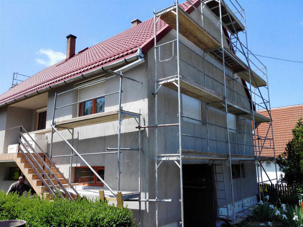 Állványozott családi ház homlokzat-felújítás közben